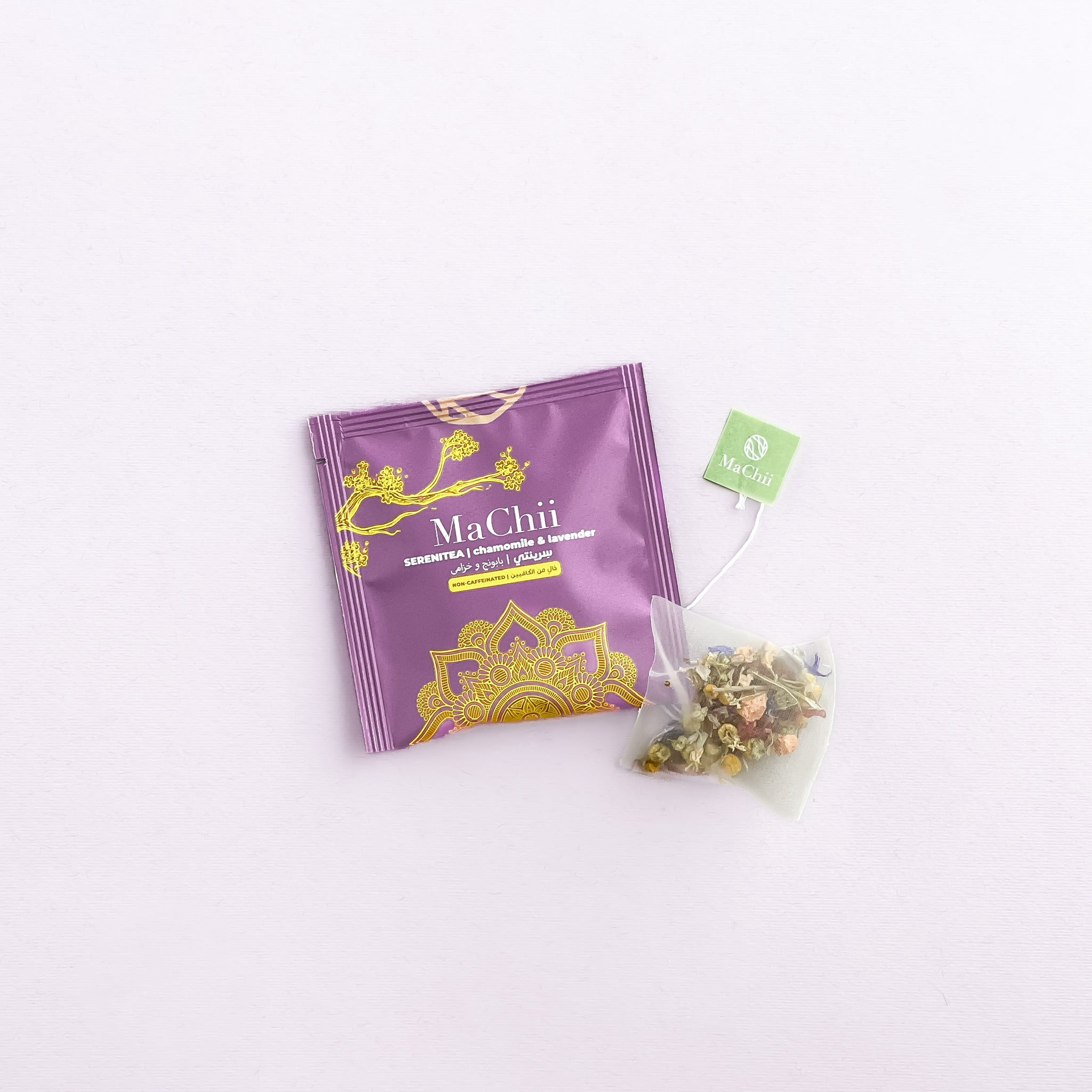 serenitea tea bag with a MaChii Tea tag on the side. the teabag is onto of the organic tea envelope which says MaChii Tea SereniTea | Chamomile and lavender. the icon of the tea is a yogi mandala 