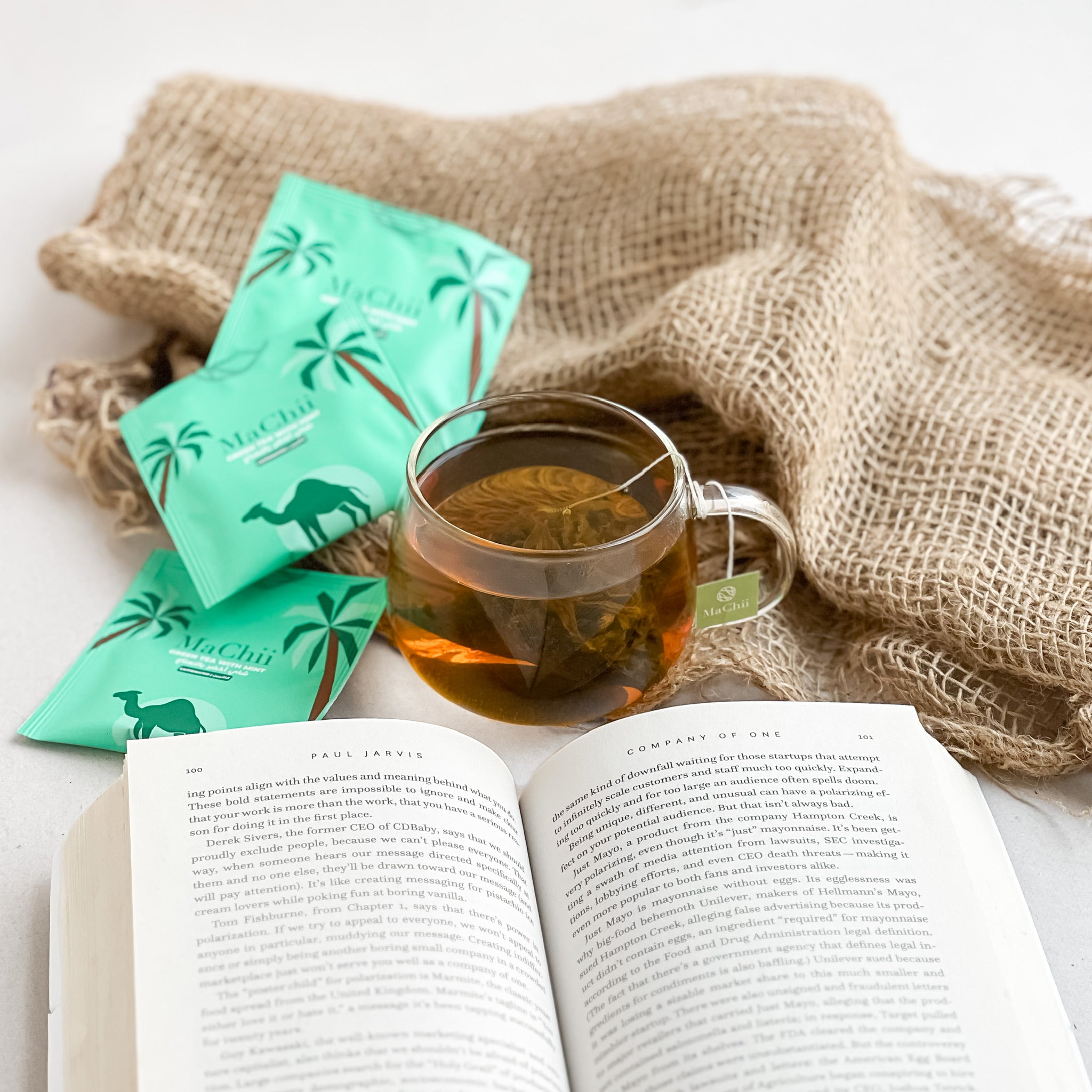 gunpowder green tea with mint brewing in a tea cup while being zen and reading a book