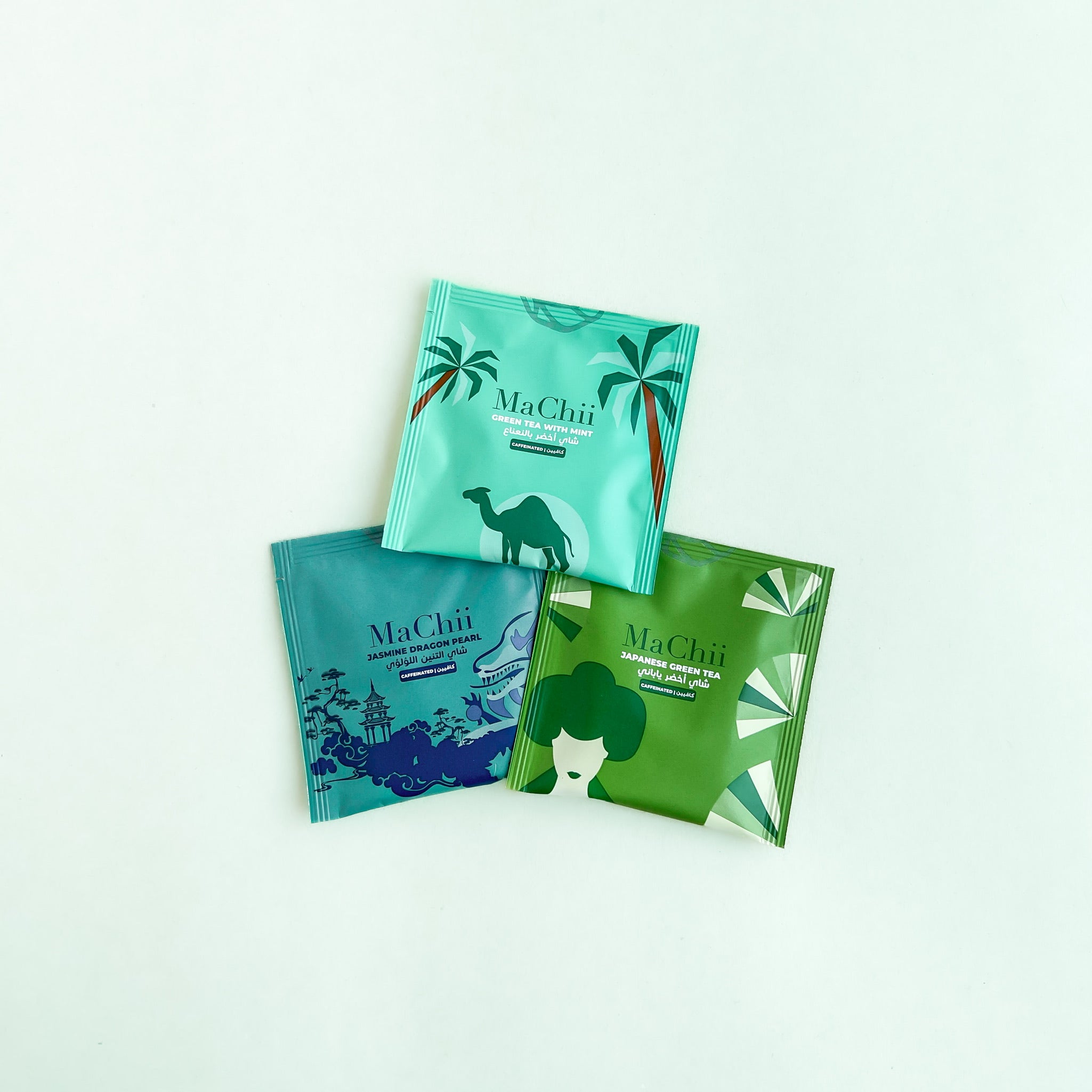 three envelope green tea packages placed in a triangle. Japanese green tea, green tea with mint and jasmine dragon pearl. the machii tea logo is on each blend.