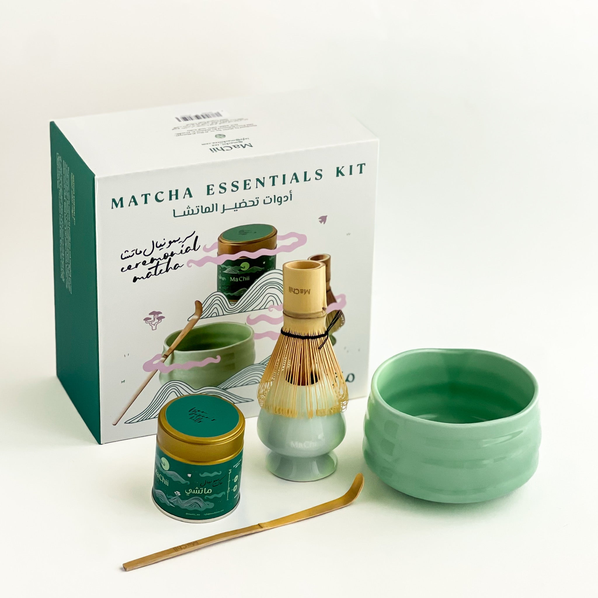 a matcha gift box with a gold organic ceremonial matcha tin, a bamboo whisk, a bamboo spoon and a green ceramic matcha bowl.