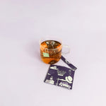 organic earl grey tea brewing in a glass cup. the tea tag is falling off the side and the packaging is wrapped open on the side, 