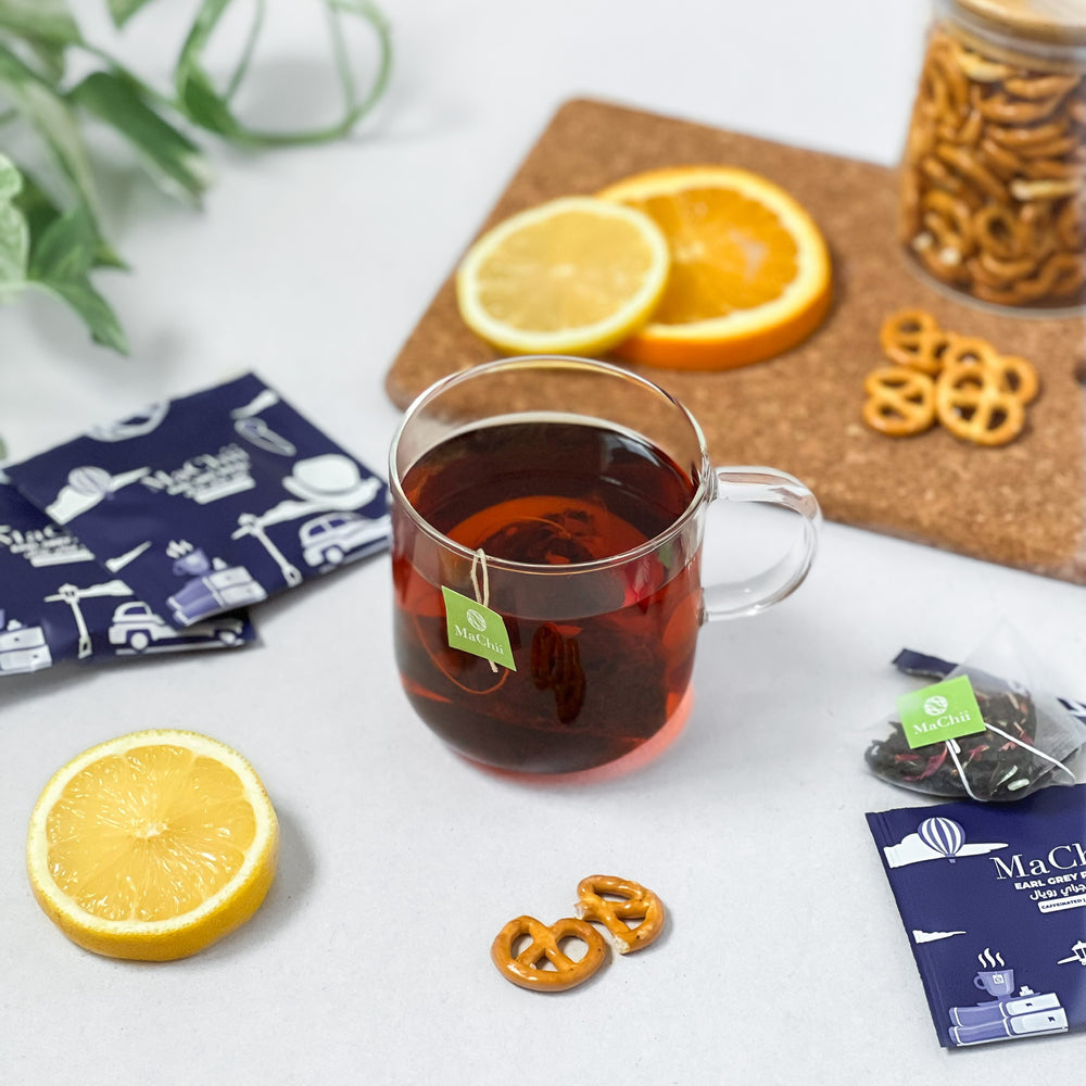 
                  
                    organic earl grey royal tea bag brewing in a mug next to English breakfast snacks. pretzels and lemons.
                  
                