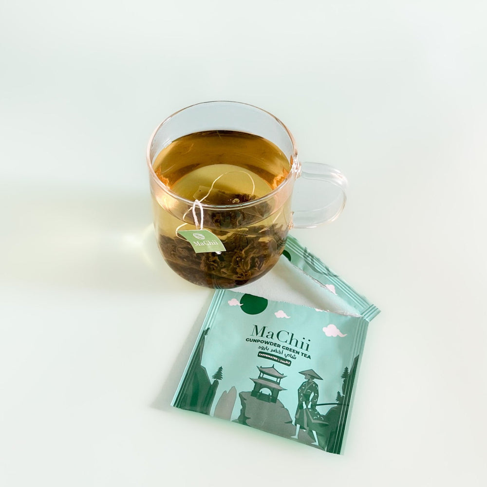 Chinese gunpowder green tea silk organic tea bag brewing in a cup