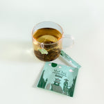 Chinese gunpowder green tea silk organic tea bag brewing in a cup