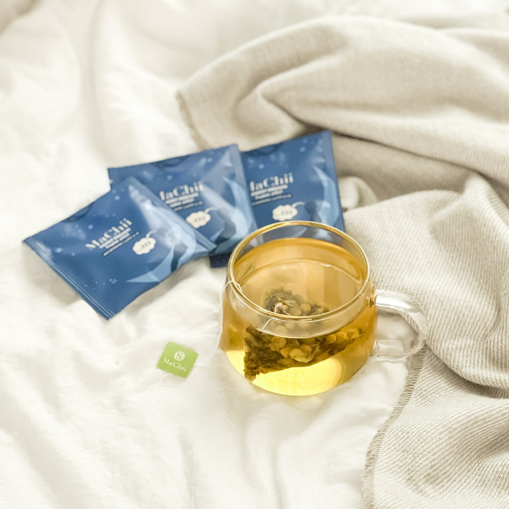 
                  
                    biodegradable herbal sleep tea bag brewing in a cup on a bed before bedtime. 
                  
                