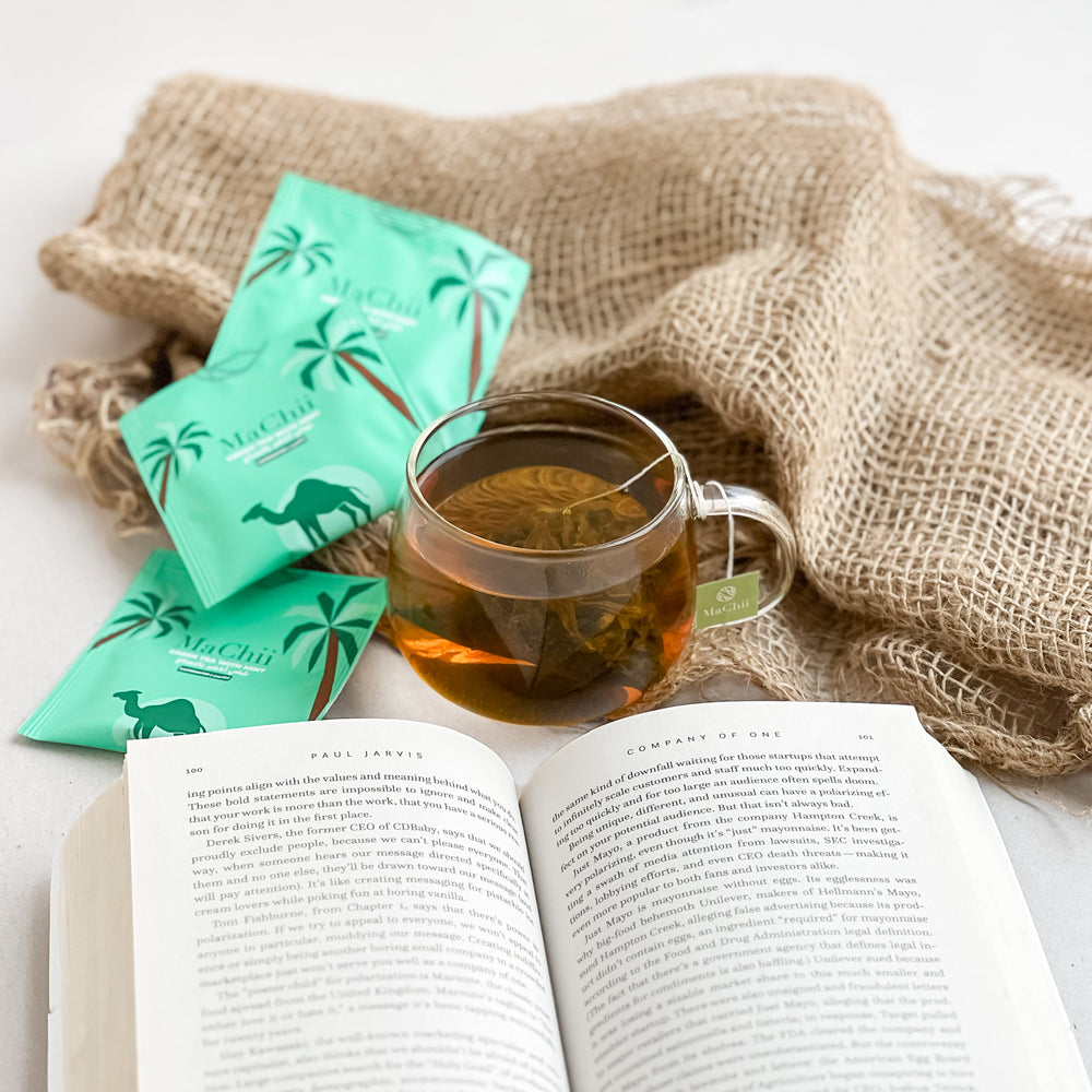 
                  
                    gunpowder green tea with mint brewing in a tea cup while being zen and reading a book
                  
                
